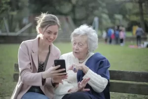 Pflegekraft mit Seniorin bei 24-Stunden-Pflege im Park